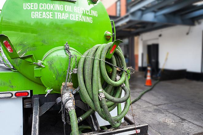 a technician pumping a grease trap in a commercial building in Prairie, MS